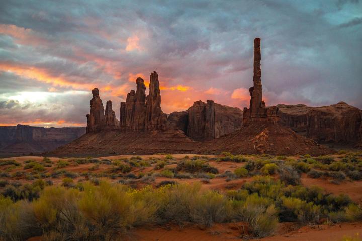 Dramatic sunset sky over Monument Valley rock formations.